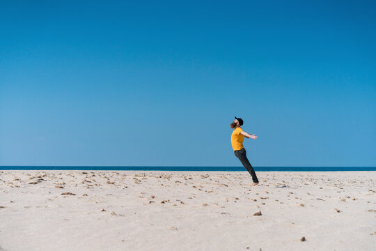 Young man with arms outstretched on beach