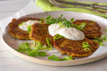 Vegetable pancakes fried with zucchi and carrots  served with a yogurt dip, chives and cress