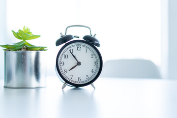 Retro alarm clock standing white table clear home background