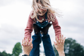 Cheerful daughter playing with father outdoors