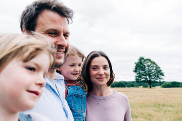 Smiling parents and daughters at meadow