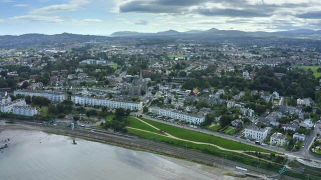Monkstown, Dublin, Ireland, September 2021. Drone gradually tracks along the coastline while orbiting Monkstown Parish Church with Killiney hill and the D&uacute;n Laoghaire in the distance.