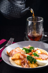 Colorful yellow hard boiled free range eggs in a creamy and mustard sauce served garnished with fresh herbs