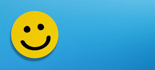 Happy smiley face emoticon with copy space on blue background