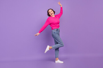Full length body size view of attractive cheerful mature woman dancing having fun isolated over violet purple color background