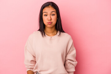 Young latin woman isolated on pink background  blows cheeks, has tired expression. Facial...