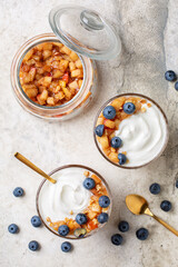 Homemade caramelized cinnamon apple and greek yogurt with blueberries and walnuts.  Directly above, vertical image.