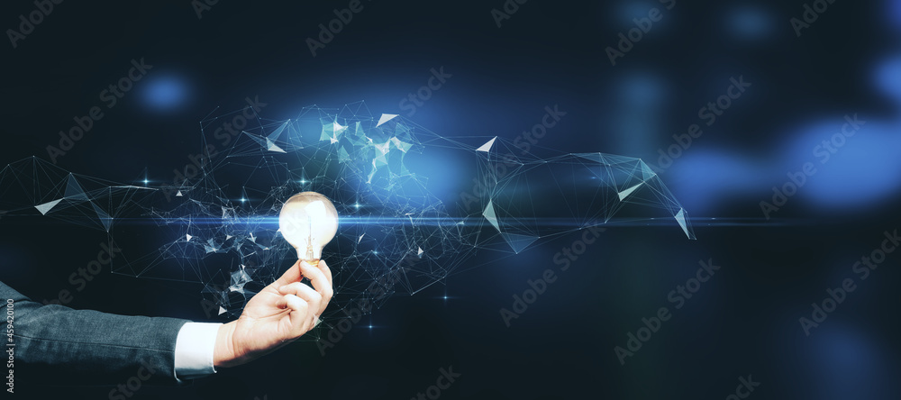 Poster close up of hand holding glowing polygonal light bulb on blurry blue background with mock up place. 