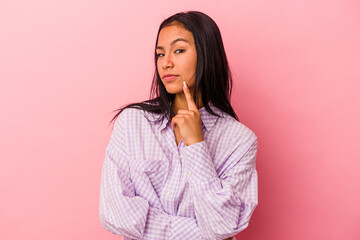 Young latin woman isolated on pink background  contemplating, planning a strategy, thinking about the way of a business.