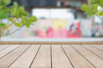 Empty wooden table top and blurred background of white counter bar in coffee shop and restaurant with tree. Can be used for display or montage for show your products.