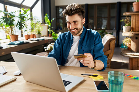 Male professional with credit card doing online shopping in office