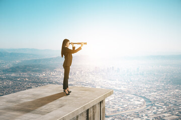 Businesswoman with telescope on abstract concrete roof looking at city skyline and sky view with...