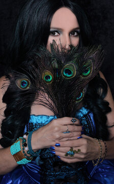 Woman in Blue Corset With Green and Black hair and peacock feathers