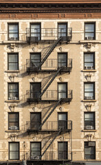 detail of old vintage brick wall facade with fire ladder and iron balconies in New York