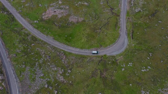 Downward angle drone shot of vehicles on Bealach Na Ba Applecross road through the mountains of the Applecross peninsula, in Wester Ross in the Scottish Highlands
