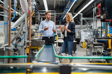 Business professionals having discussion while standing at production line