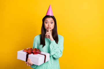 Photo of shocked scared young woman hold finger face mouth gift birthday isolated on yellow color...