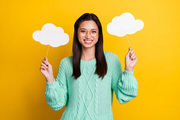 Photo of charming happy young woman wear glasses hold hands clouds weather isolated on yellow color background