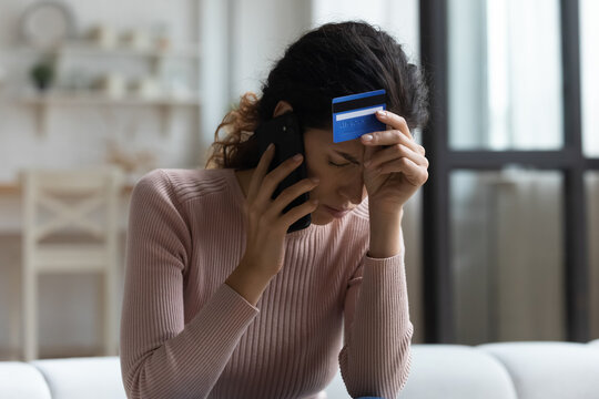 Unhappy millennial Caucasian female talk speak on cellphone with bank distressed with credit card insufficient funds. Upset young woman stressed with financial problems. Bankruptcy, debt concept.