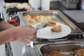 Woman taking food from a buffet line