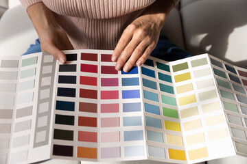 Crop close up of woman look at color palette decorate house or apartment. Caucasian female designer...