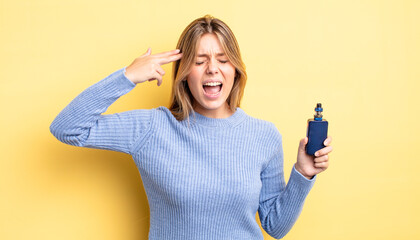 pretty blonde girl looking unhappy and stressed, suicide gesture making gun sign. smoke vaporizer...