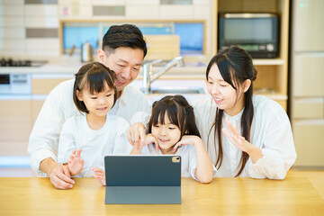 タブレットPCの画面を見る親子