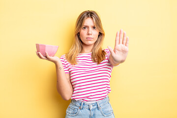 pretty blonde girl looking serious showing open palm making stop gesture. empty bowl concept © kues1