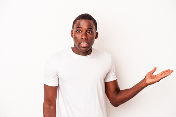 Young African American man isolated on white background impressed holding copy space on palm.