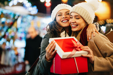 Happy women friends exchanging christmas present. Happiness people friend shopping xmas concept