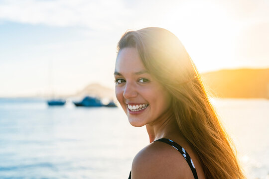 Woman with long hair smiling at beach