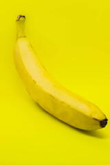 One banana on a yellow background