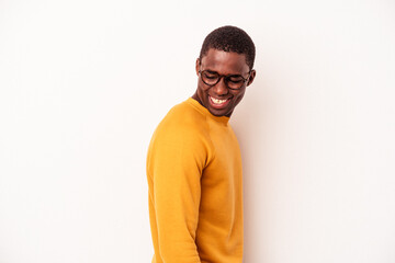 Young African American man isolated on white background looks aside smiling, cheerful and pleasant.
