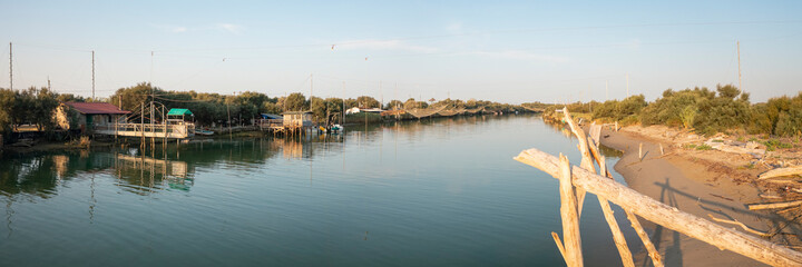 Landscape of fishing huts in the river with typical italian fishing machine, called...