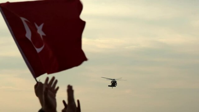 Izmir, Turkey - September 9, 2021: Close up shot of a waving Turkish Flag with Helicopters demonstrate in the sky celebrations of liberation day of Izmir 