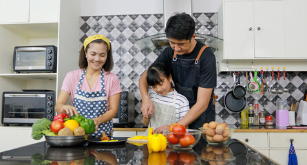 Asian family is enjoying cooking in the kitchen at home.