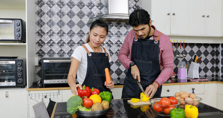 Asian couple enjoying cooking in the kitchen at home