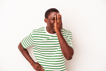 Young African American man isolated on white background having fun covering half of face with palm.