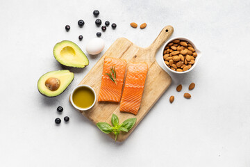 Fototapeta na wymiar A piece of red fish on a wooden board. An assortment of useful protein sources and products for strengthening the body. Keto diet.
