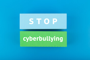 Stop cyberbullying concept. Minimal flat lay with stop cyberbullying inscription on colored rectangles on blue background. 