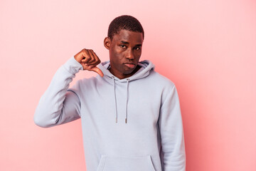 Young African American man isolated on pink background showing a dislike gesture, thumbs down. Disagreement concept.