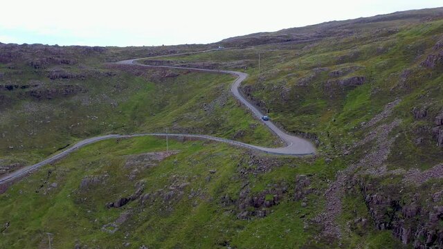 Revealing drone shot of twisting road on Bealach Na Ba Applecross road through the mountains of the Applecross peninsula, in Wester Ross in the Scottish Highlands