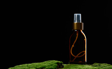brown glass spray bottle stands on green moss