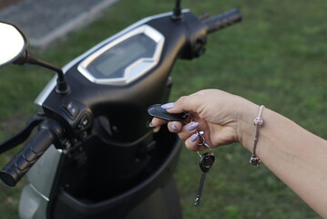 Female Hand Closes And Opens The Electric Scooter With The Alarm Remote