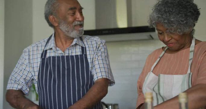 Animation of midsection of happy african american senior couple cooking together