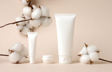 jar and empty white plastic tubes for cosmetics on a green background. Packaging for cream, gel, serum, advertising and product promotion, mock up