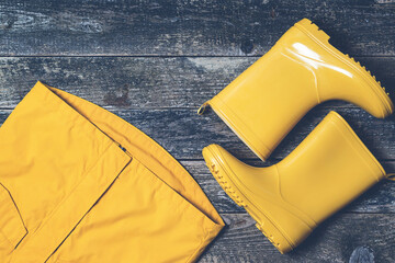 Autumn outfit for kids. Flat lay, top view. Yellow rain boots and raincoat. Autumn fashion.