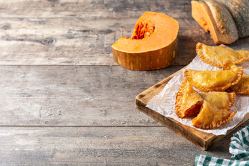 Pumpkin empanadillas on rustic wooden table. copy space