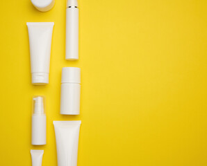 jar, bottle and empty white plastic tubes for cosmetics on a yellow background. Packaging for cream, gel, serum, advertising and product promotion, mock up