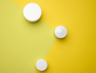 white jar for cosmetics on a green table. Packaging for cream, gel, serum, advertising and product promotion, mock up, top view